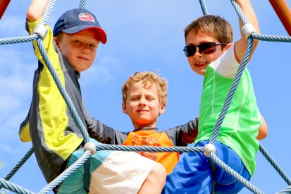 Campers sitting on climbing ropes.