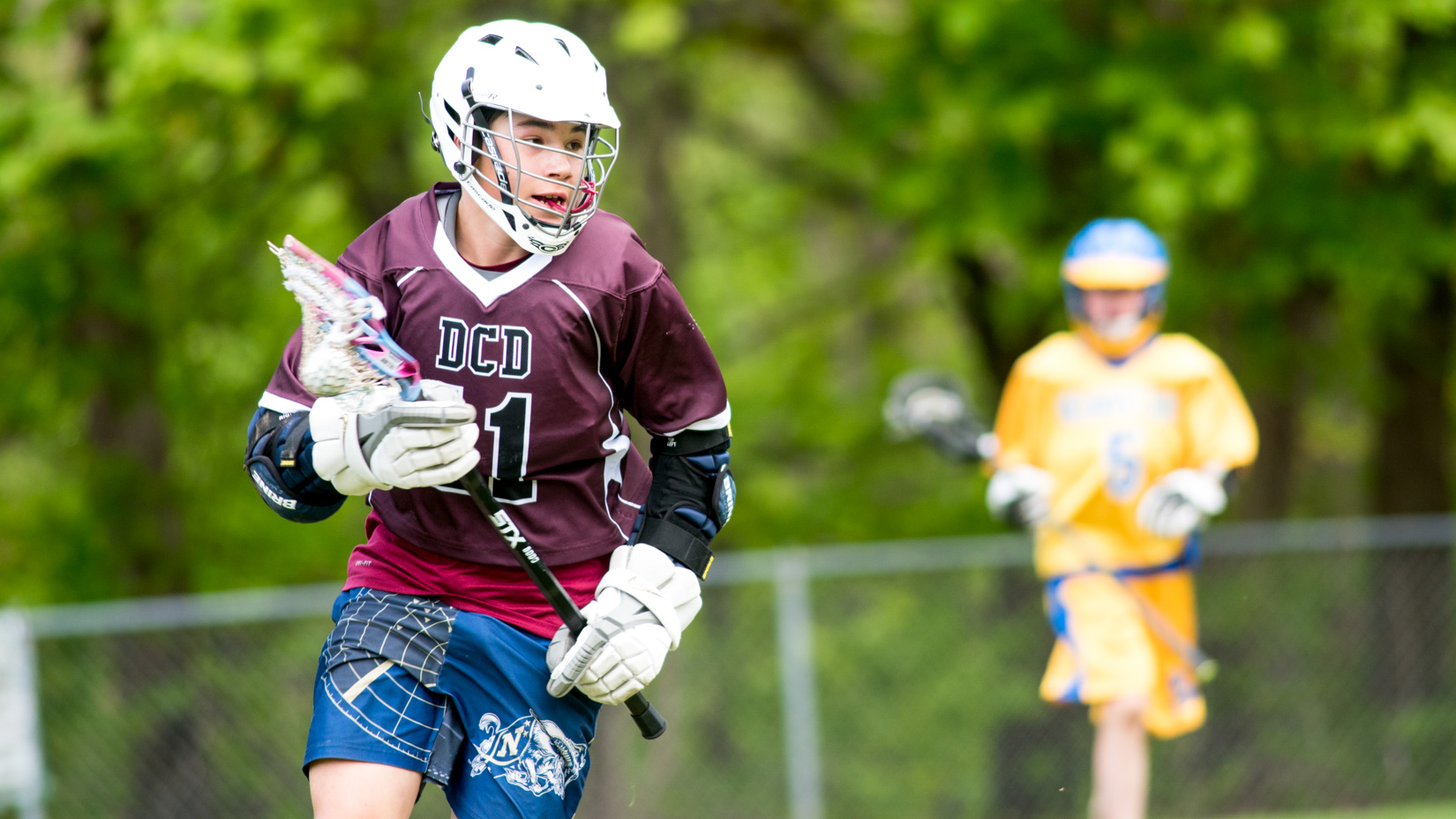 A student playing lacrosse.