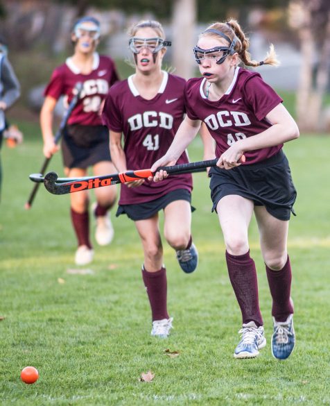 Students playing field hockey.