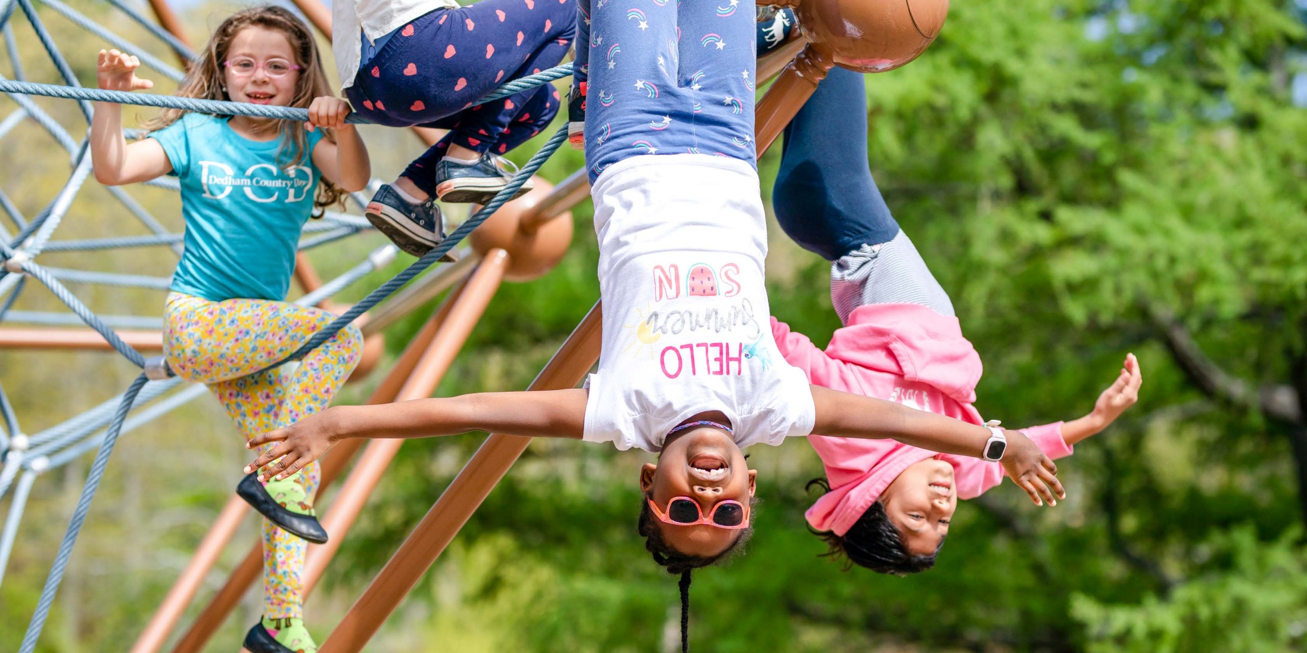 Students playing on the climbing ropes on the playground.