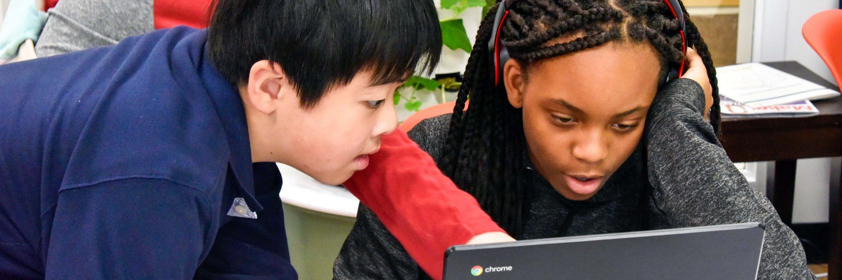 A group of students around a computer.