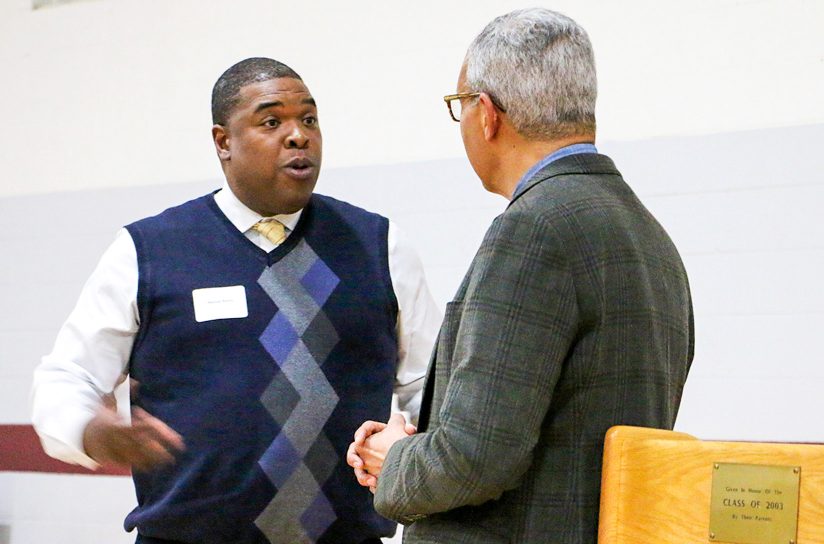 Two people standing on stage about to give a presentation or speech.