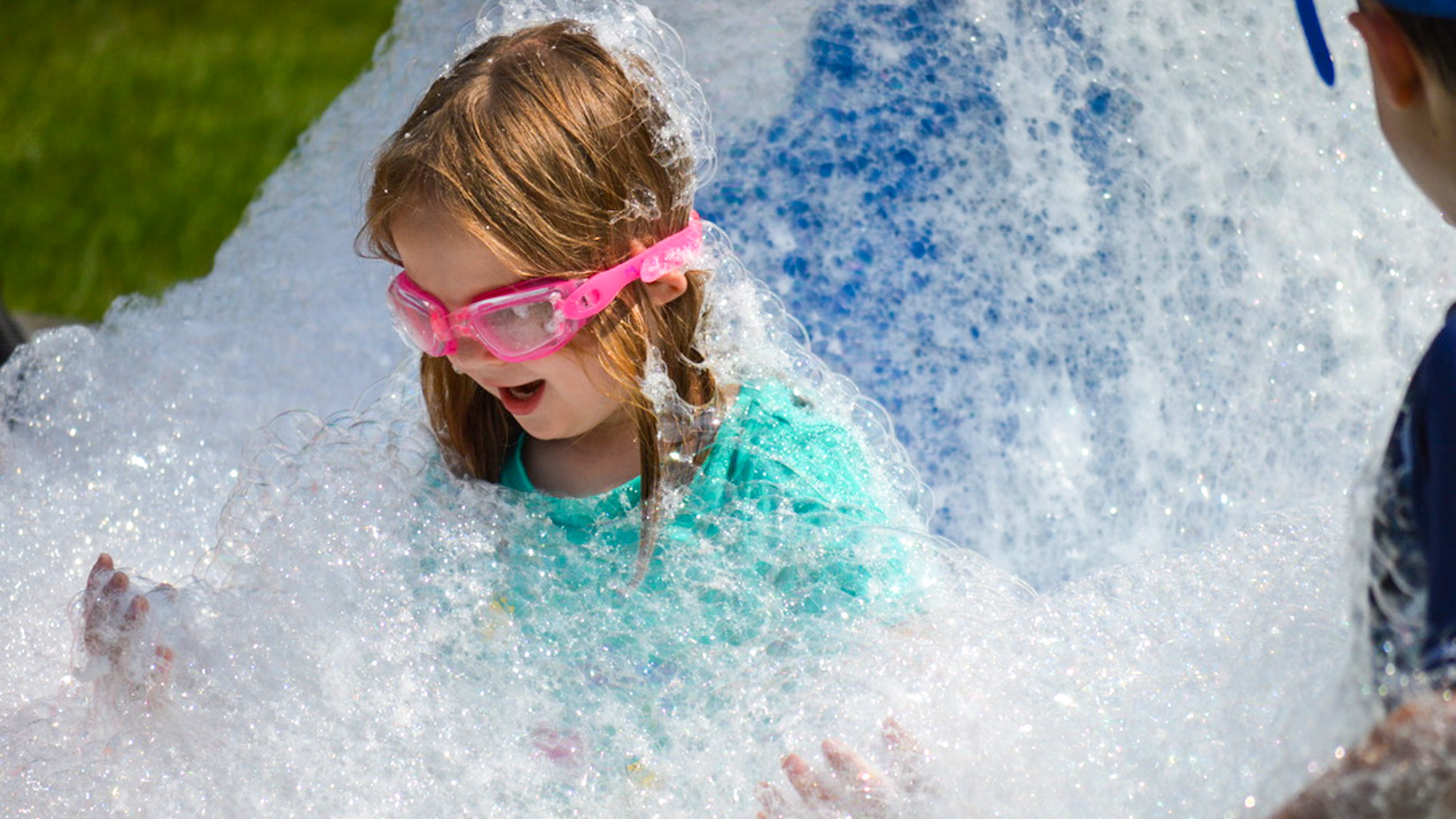 A camper amazed at the amount of soap bubbles around her.