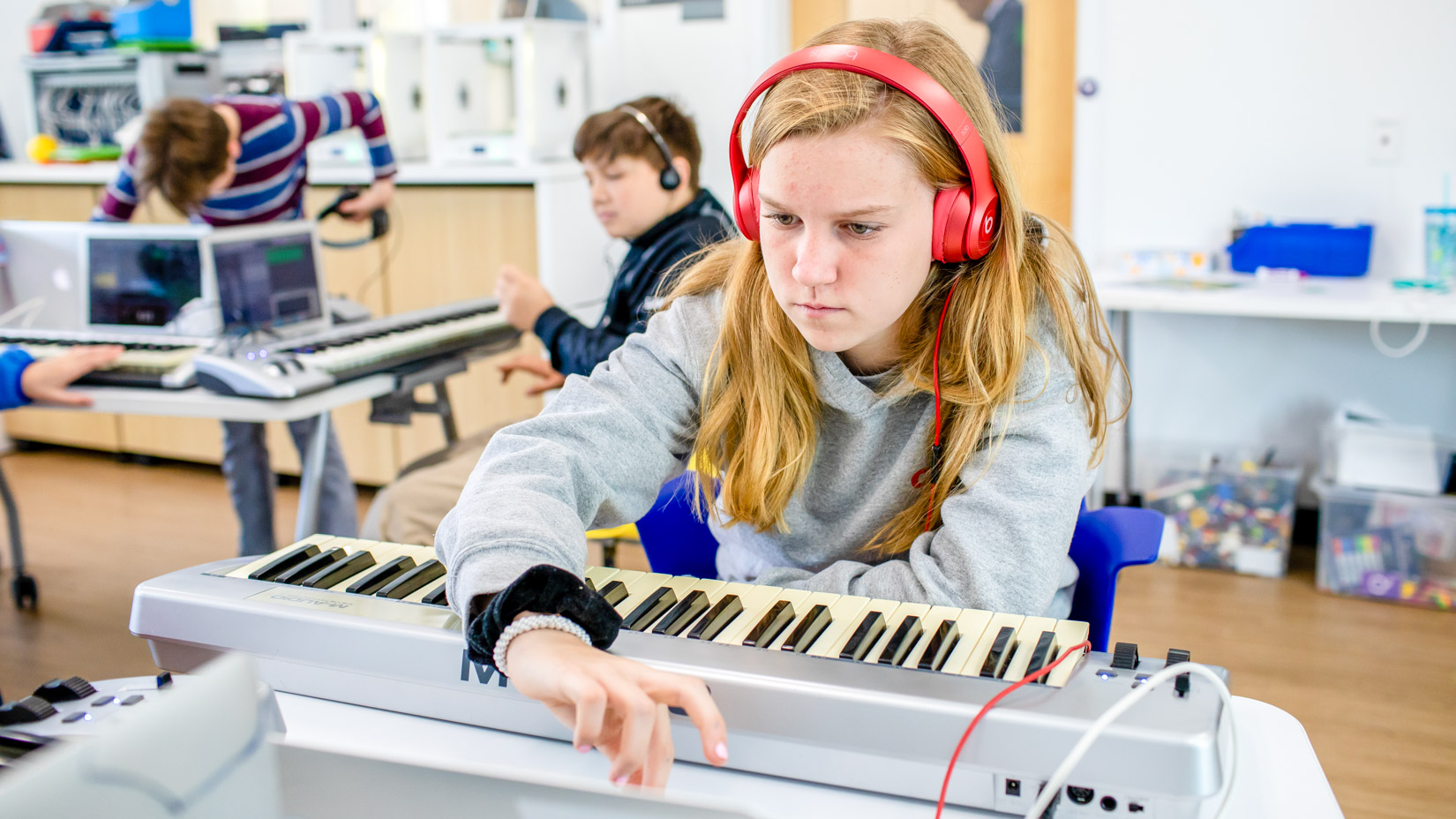 A student playing music on an electronic keyboard.