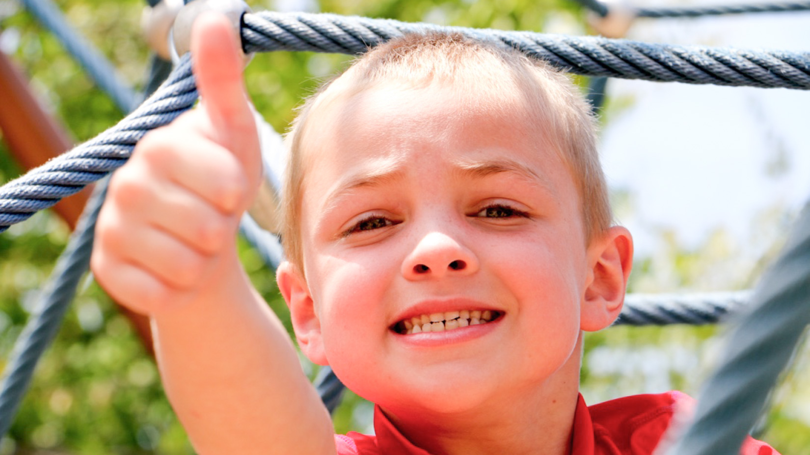 A camper smiling and giving the camera thumbs up.