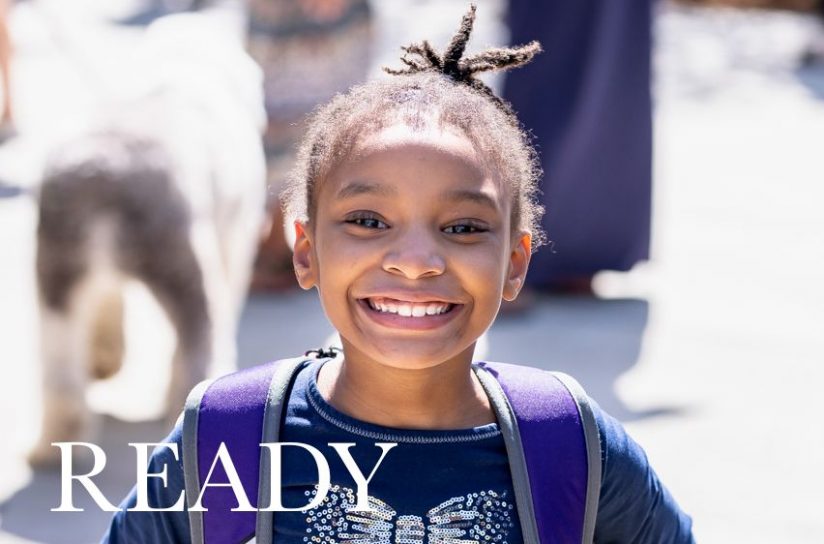 A young girl smiling at the camera.