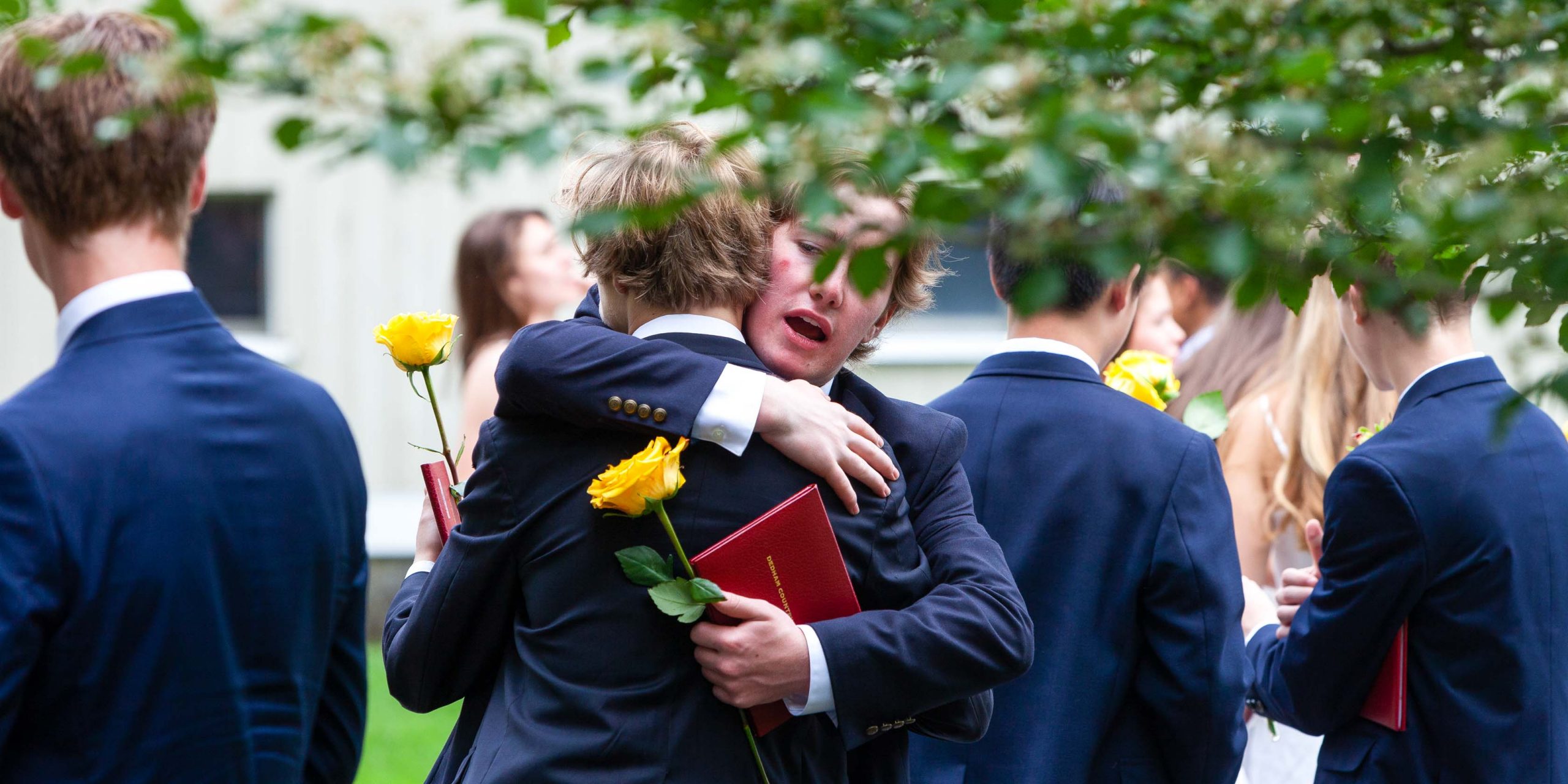 Students hugging after the graduation ceremony.