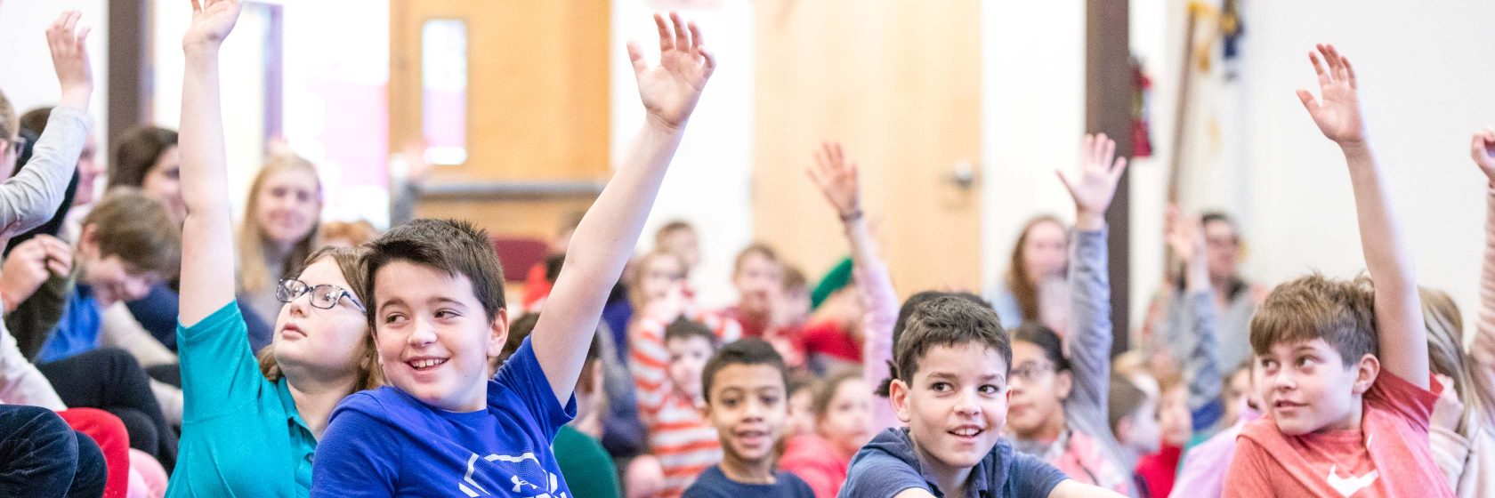 Students raising their hands during a class.