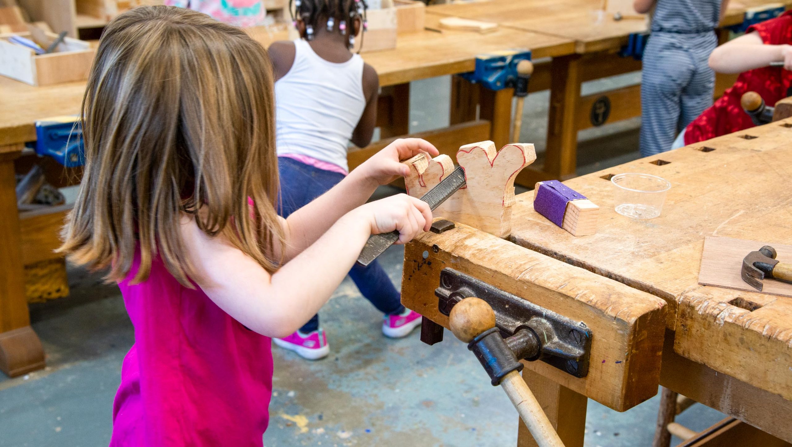 A student filing down a wooden project.