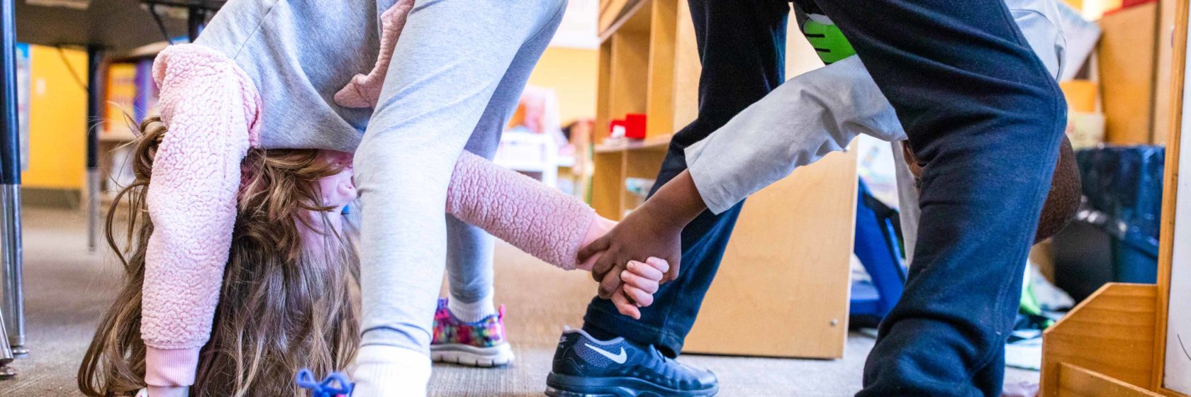 Students holding hands during a stretching exercise.