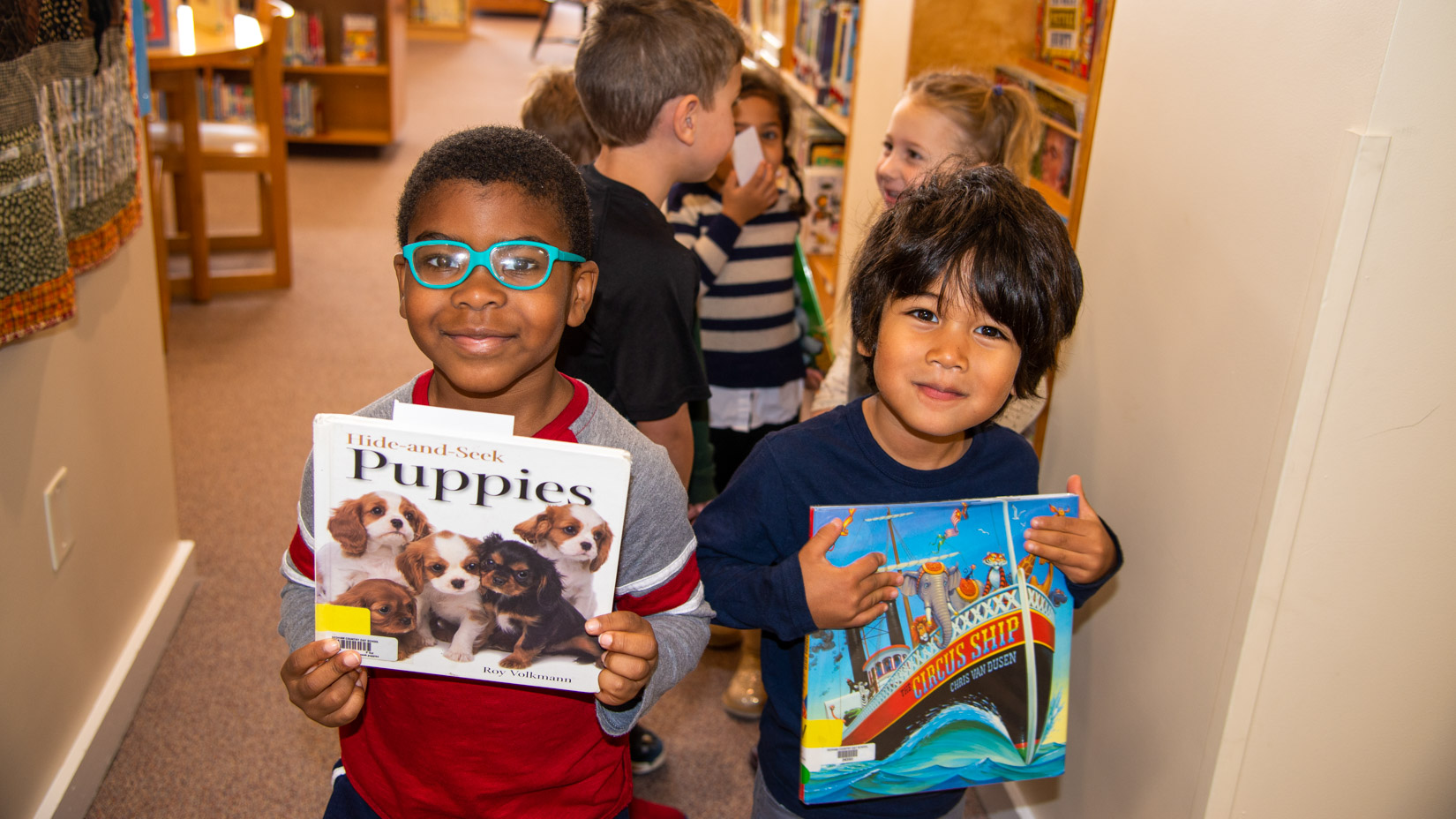 Students picking out books on topics they are interested in in the library