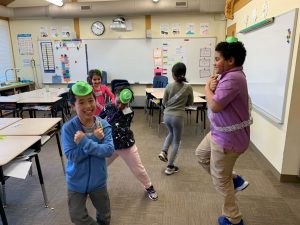 Children representing different ethnicities dancing in the classroom