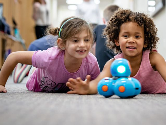 Children playing with a robot to learn more about technology.