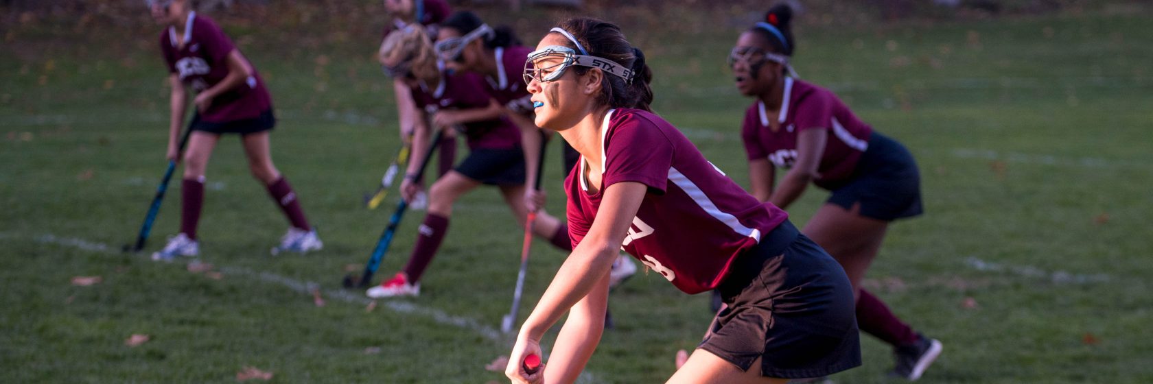 A student playing field hockey.