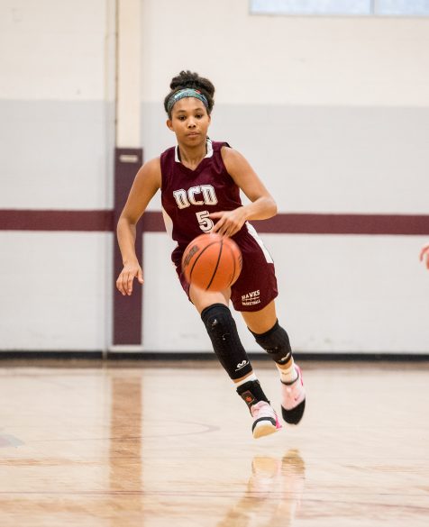 A basketball player running down the court.