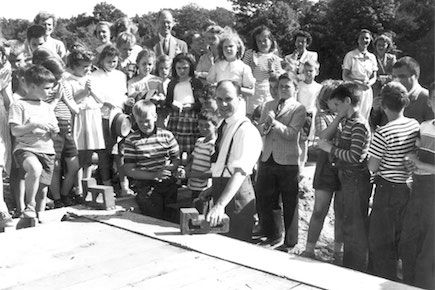 Board President Nelson Bigelow lays the cornerstone of the new school building on Sandy Valley Road.