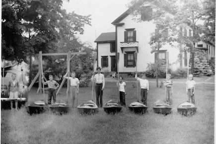 Students pose with the kayaks they made in woodshop in the 1940s.