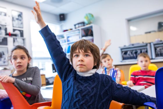A student raising their hand in class.