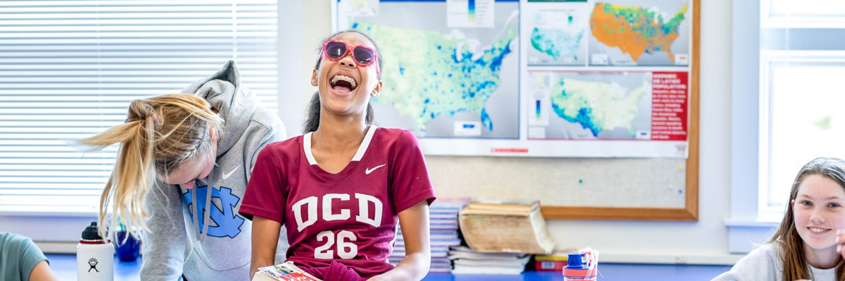 Students smiling and laughing in a classroom.