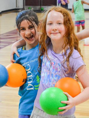 Campers smiling while playing dodgeball.