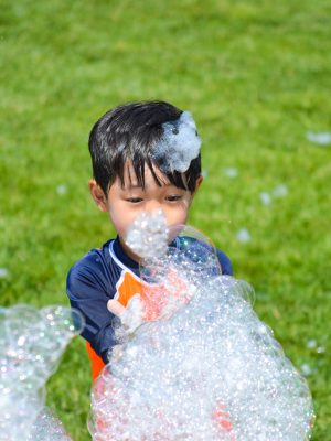 A young camper playing with bubbles.