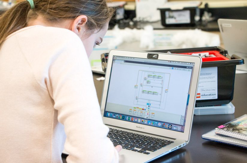 A student programming on her computer.