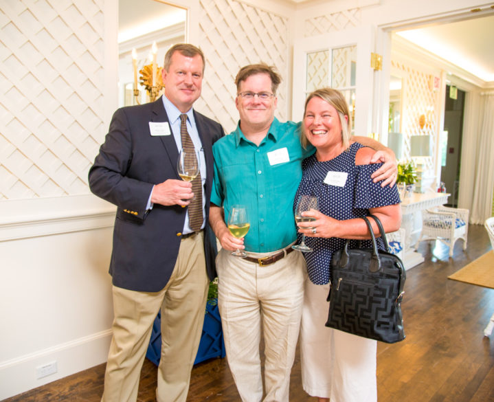Alumni smiling at the camera at an event