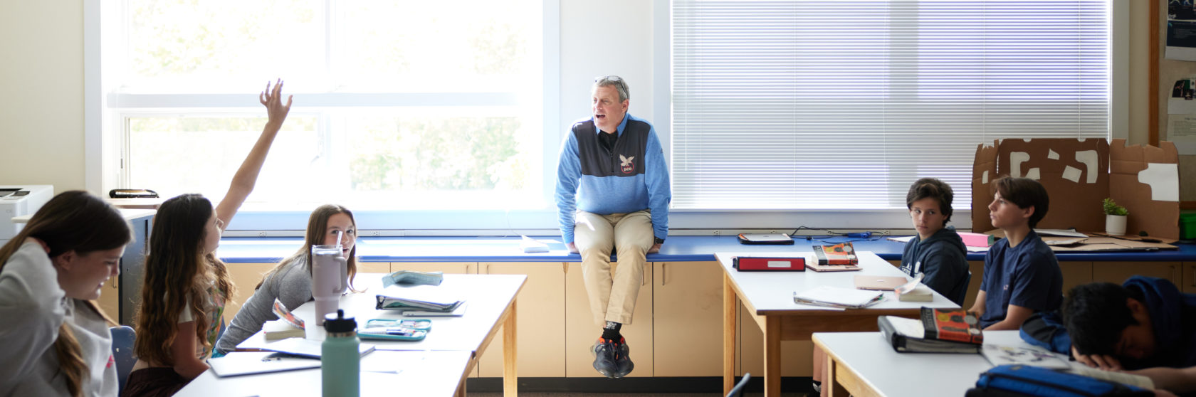 A middle-school teacher leads discussion in the classroom.