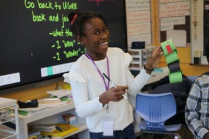 Girl holding up a paper chain snake celebrating the Chinese New Year